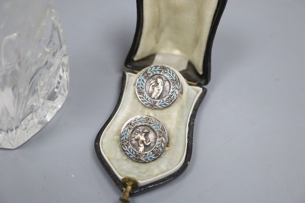 A cased pair of French white metal and enamel lapel buttons and a silver and enamel mounted glass scent bottle